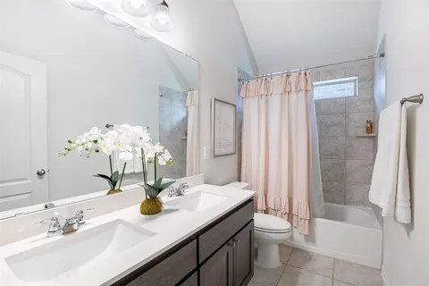 a bathroom with a granite countertop sink a toilet and shower