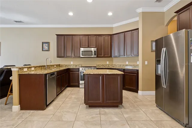 a kitchen with a refrigerator and a stove top oven