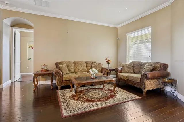 a living room with furniture chess board and wooden floor
