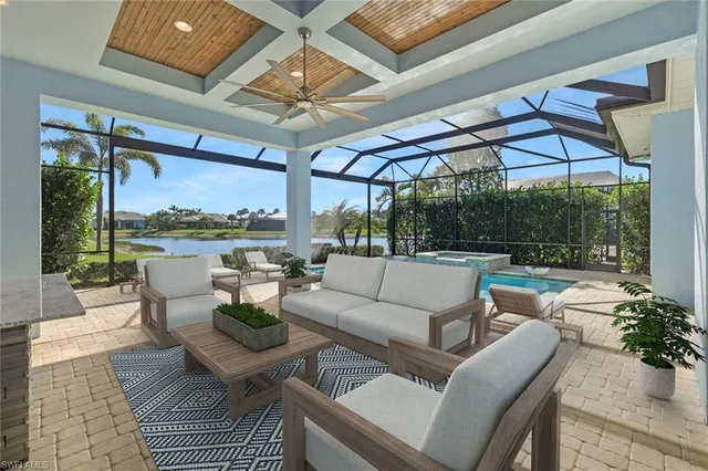 a living room with patio furniture and a floor to ceiling window