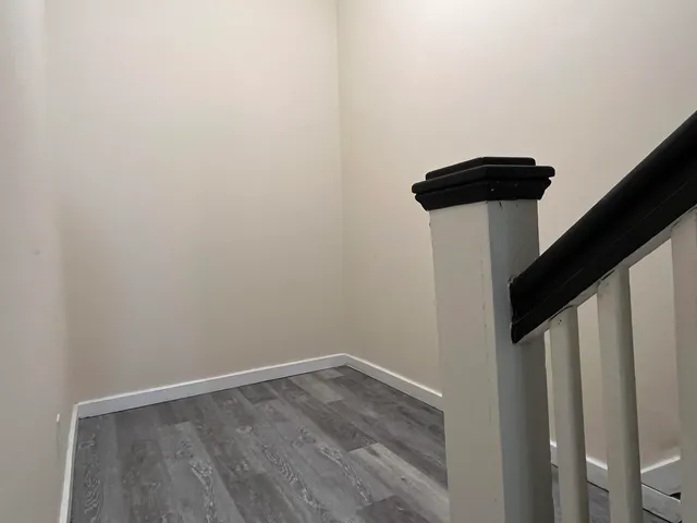 a view of a hallway with wooden floor and staircase