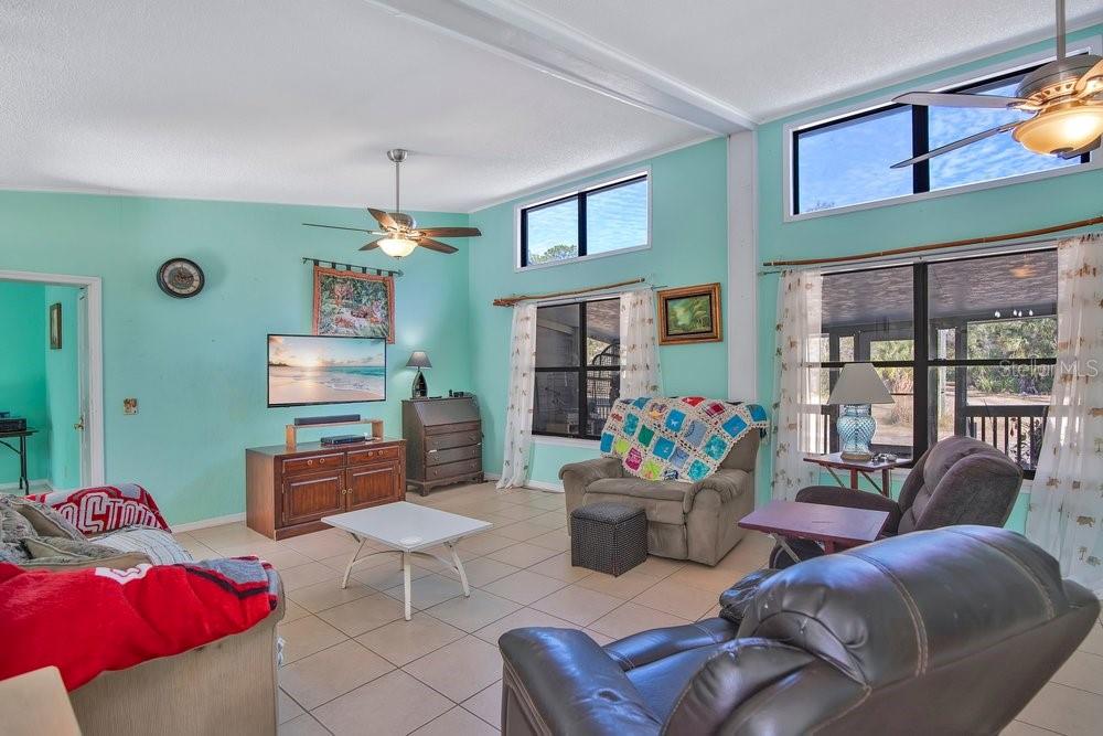 425 Scooter Point Geneva, FL 32732 - Photo 10 of 41 a living room with furniture a chandelier and a fireplace