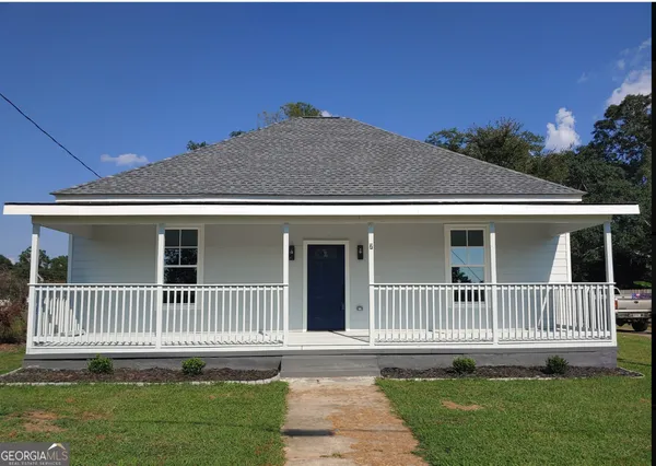 a front view of a house with a garden and deck