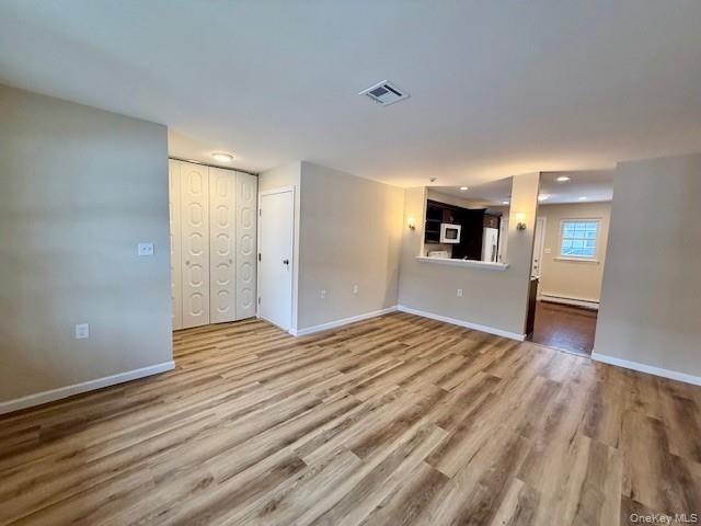 373 Woodbridge Drive, Unit B Ridge, NY 11961 - Photo 11 of 23 a view of empty room with wooden floor and fireplace