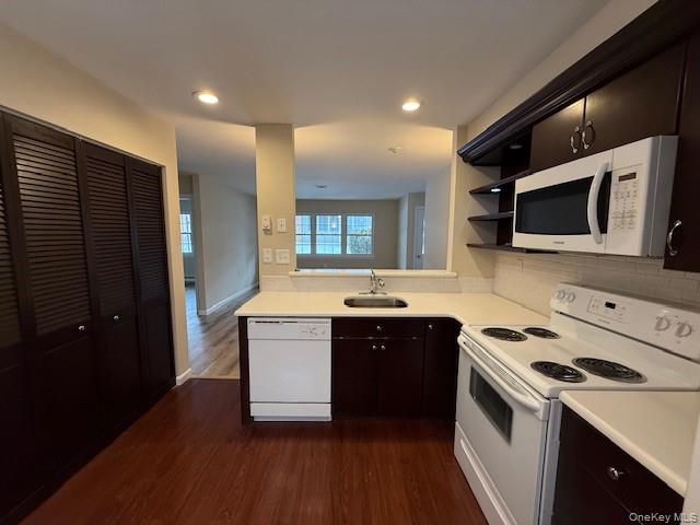 373 Woodbridge Drive, Unit B Ridge, NY 11961 - Photo 4 of 25 Kitchen featuring white appliances, light countertops, tasteful backsplash, dark wood-style floors, and open shelves