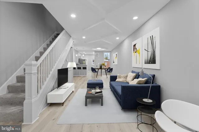 a living room with furniture a rug and white walls