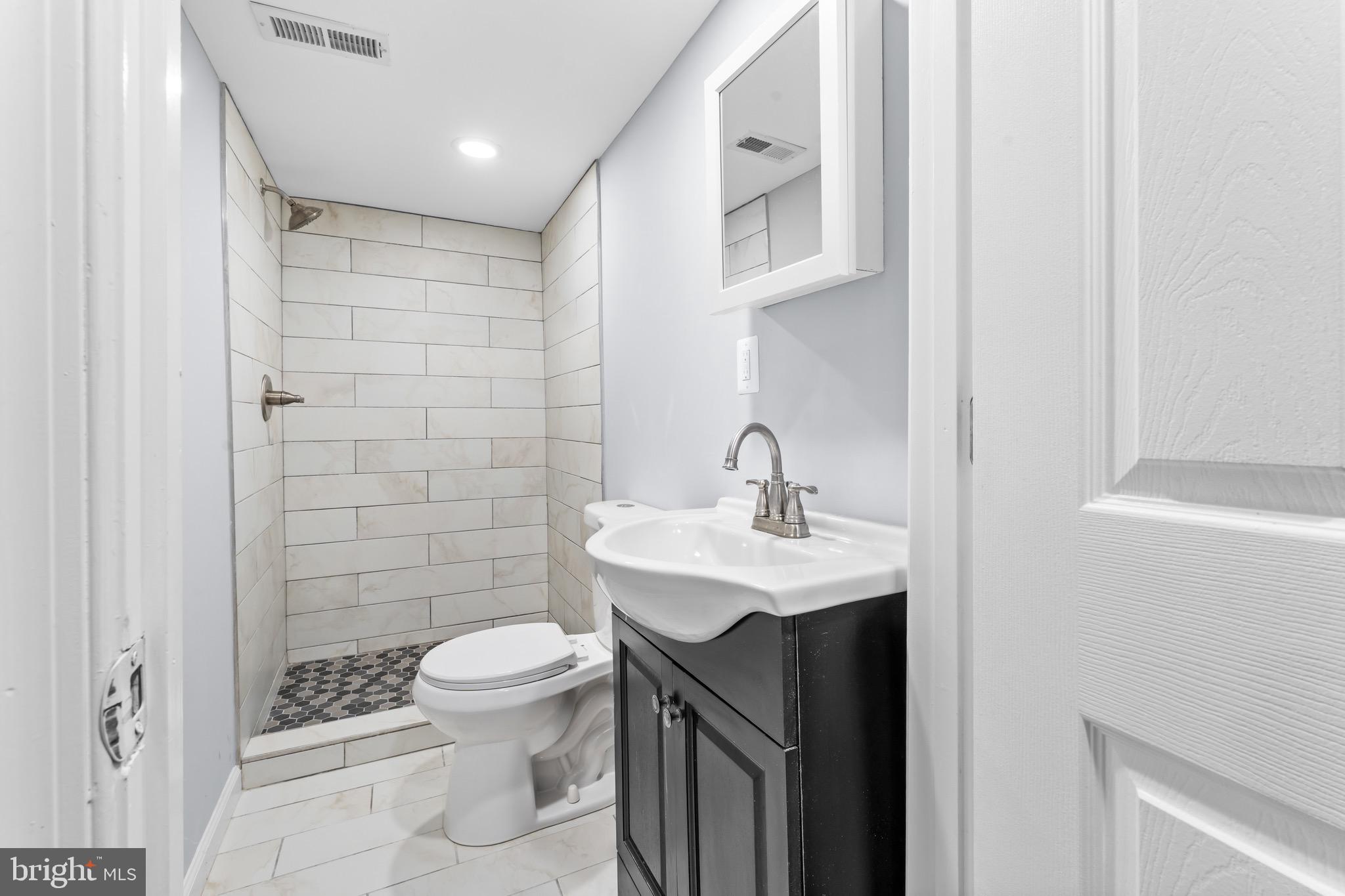 3904 Woodridge Road Baltimore, MD 21229 - Photo 14 of 17 a bathroom with a sink a toilet and shower