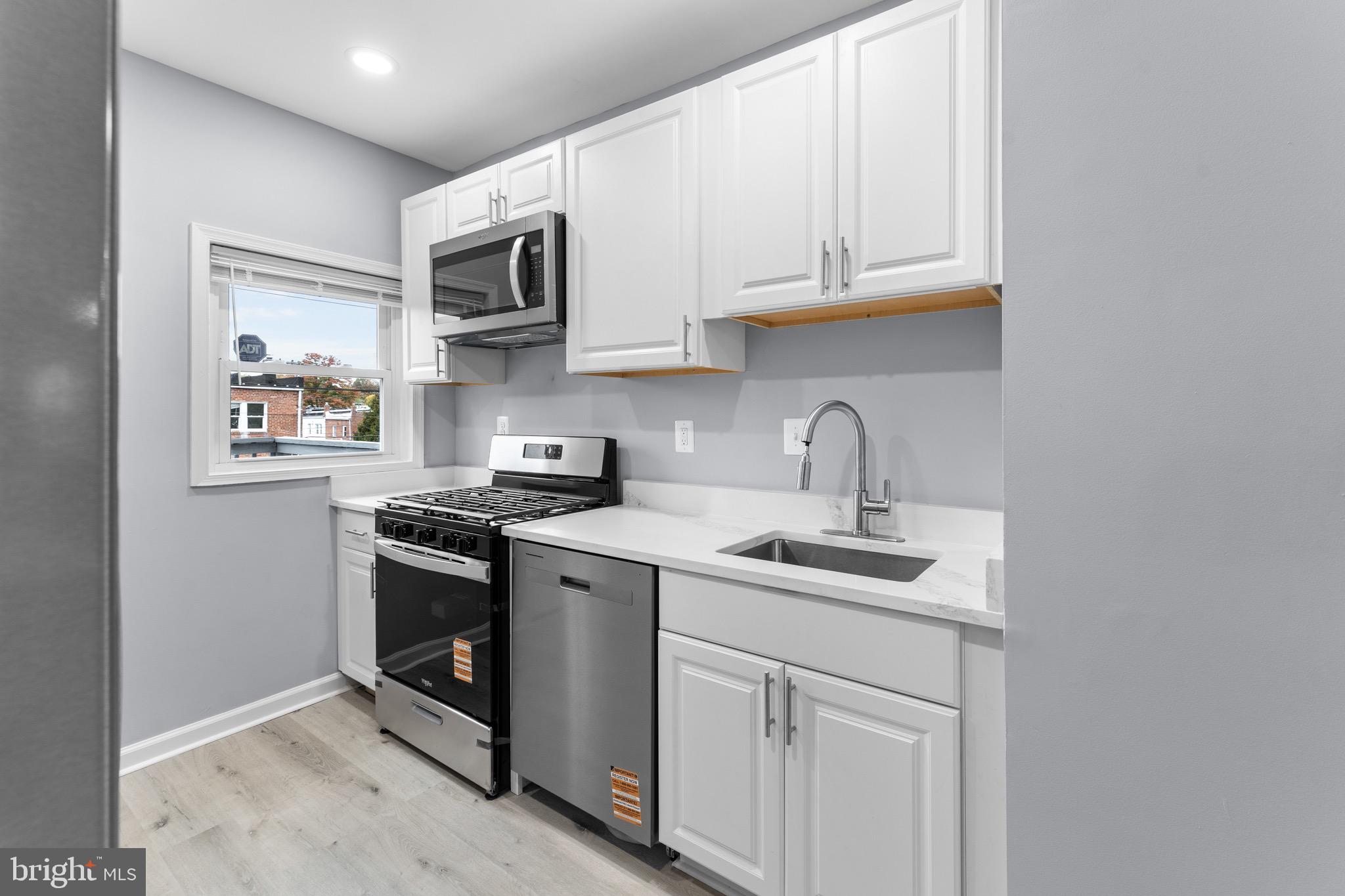 3904 Woodridge Road Baltimore, MD 21229 - Photo 7 of 17 a kitchen with stainless steel appliances granite countertop a sink stove and microwave