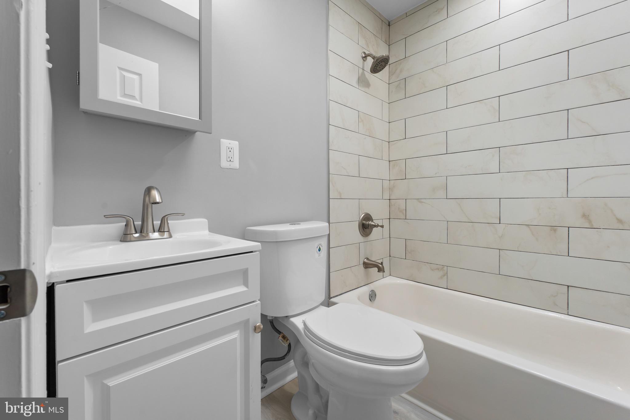 3904 Woodridge Road Baltimore, MD 21229 - Photo 8 of 17 a bathroom with a sink a toilet and shower