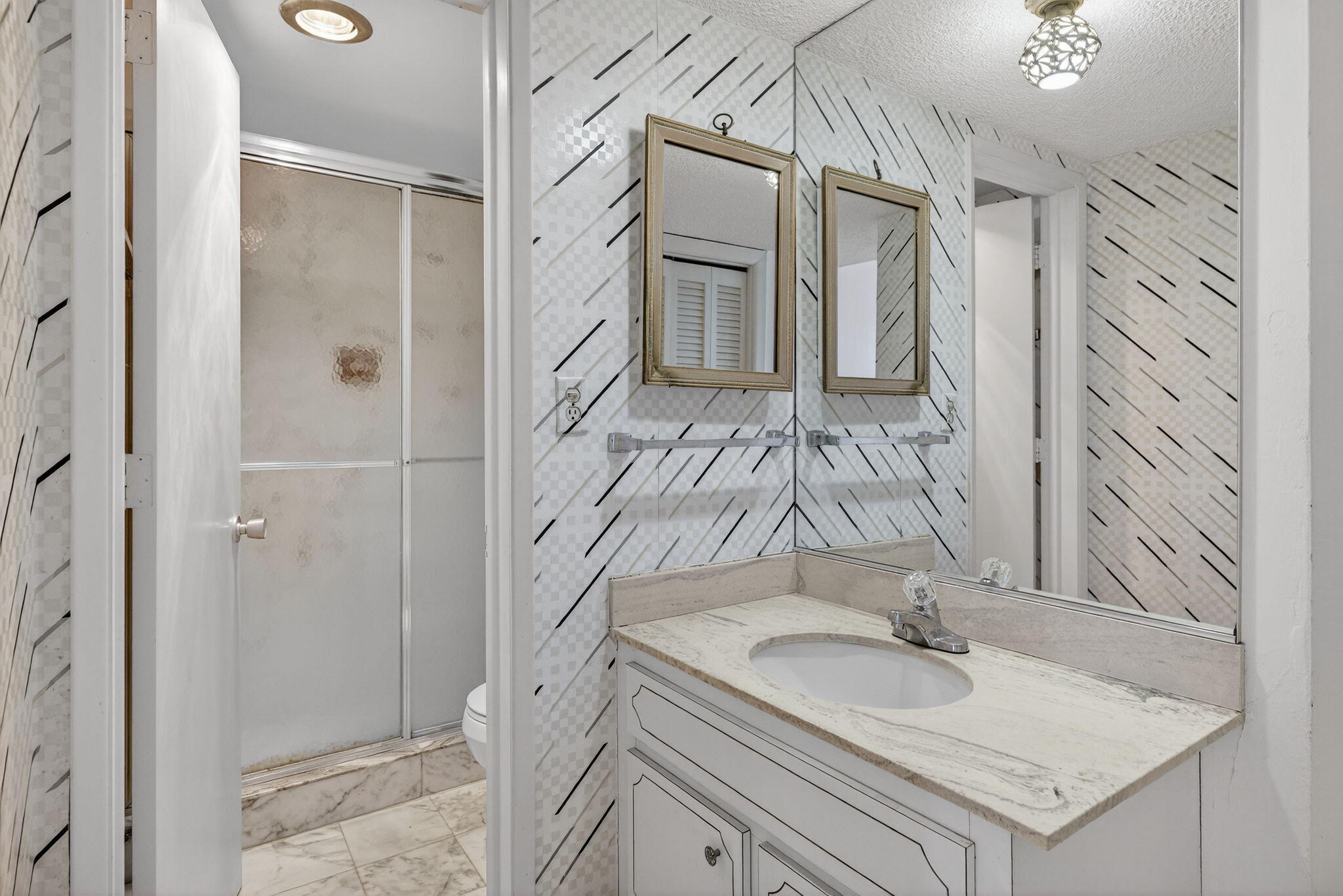 1069 Hillsboro Mile, Unit 802 Hillsboro Beach, FL 33062 - Photo 16 of 47 a bathroom with a granite countertop sink a mirror and shower