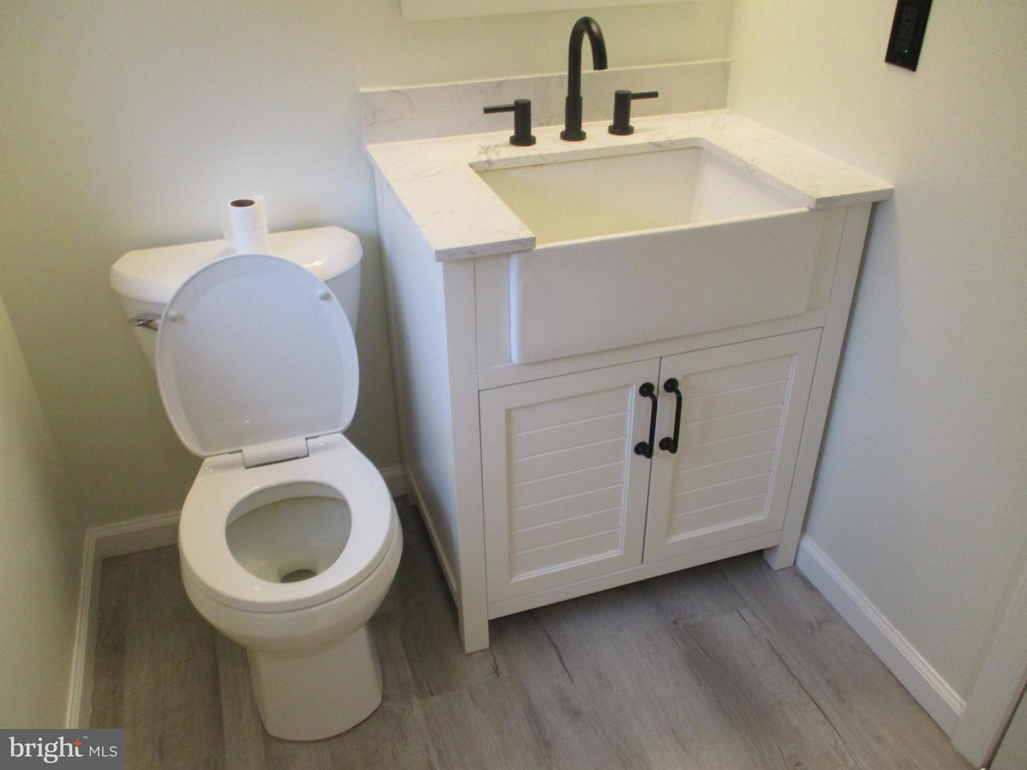 3831 8th Street North Beach, MD 20714 - Photo 15 of 37 a bathroom with a toilet sink and mirror