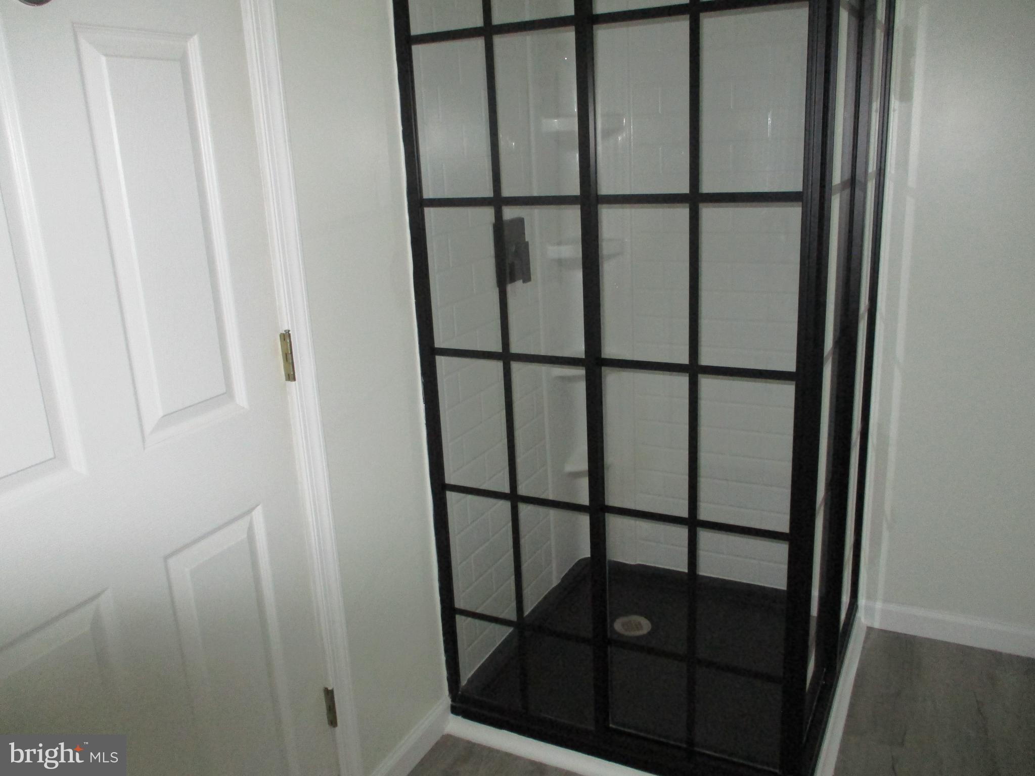 3831 8th Street North Beach, MD 20714 - Photo 17 of 37 a bathroom with a glass shower door