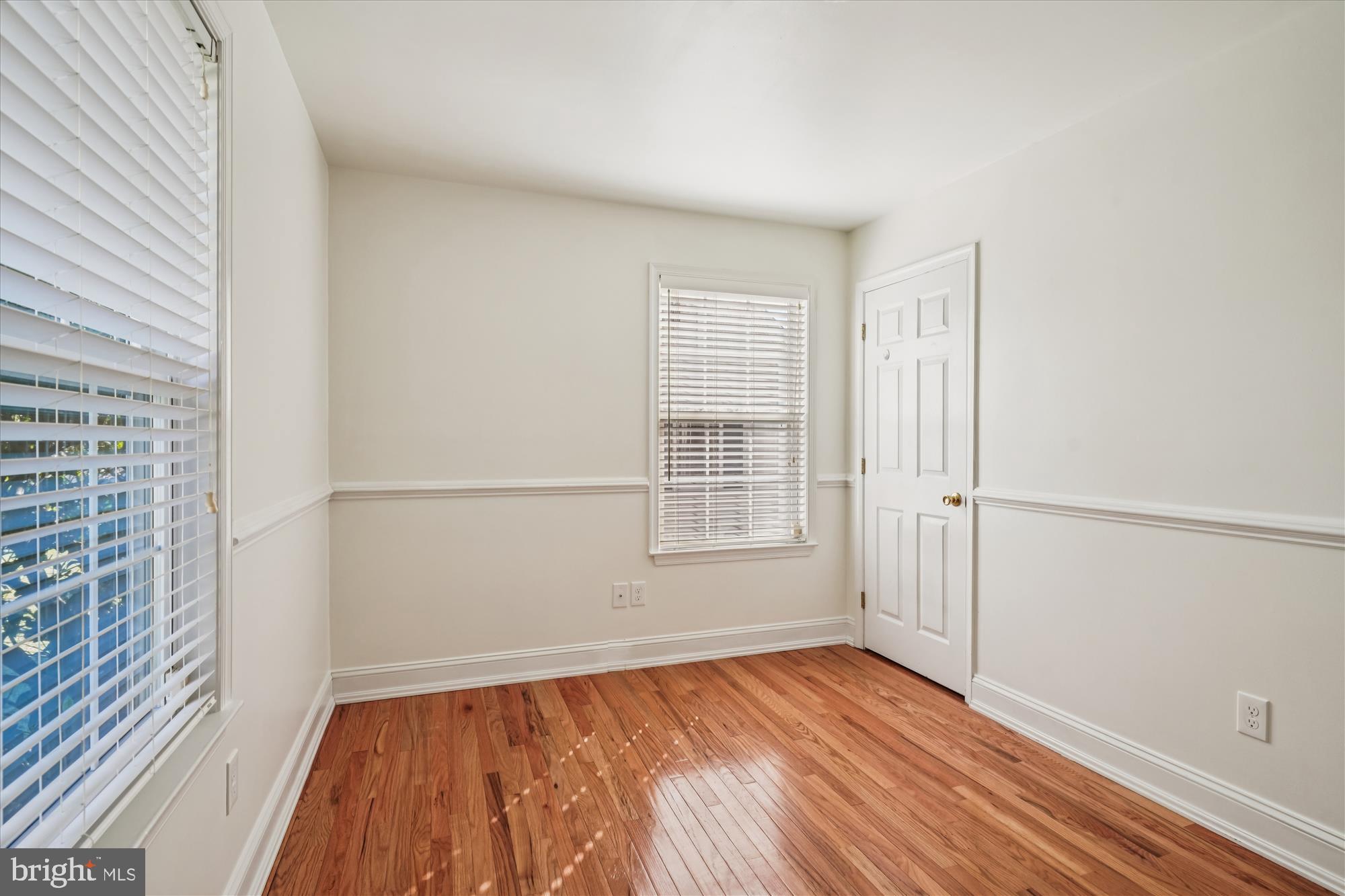 3831 8th Street North Beach, MD 20714 - Photo 19 of 37 an empty room with wooden floor and windows