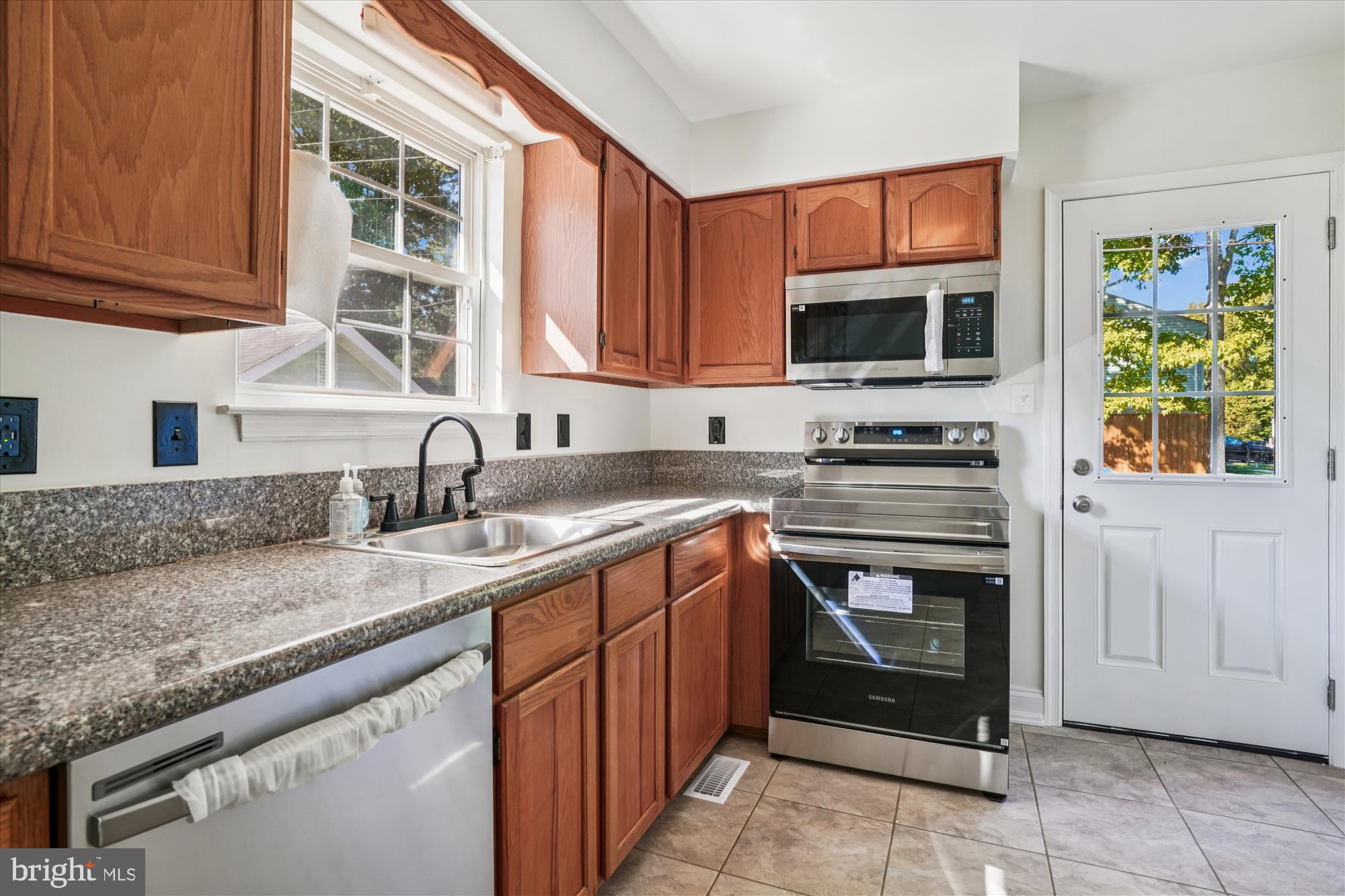 3831 8th Street North Beach, MD 20714 - Photo 6 of 37 a kitchen with stainless steel appliances granite countertop a stove microwave and cabinets