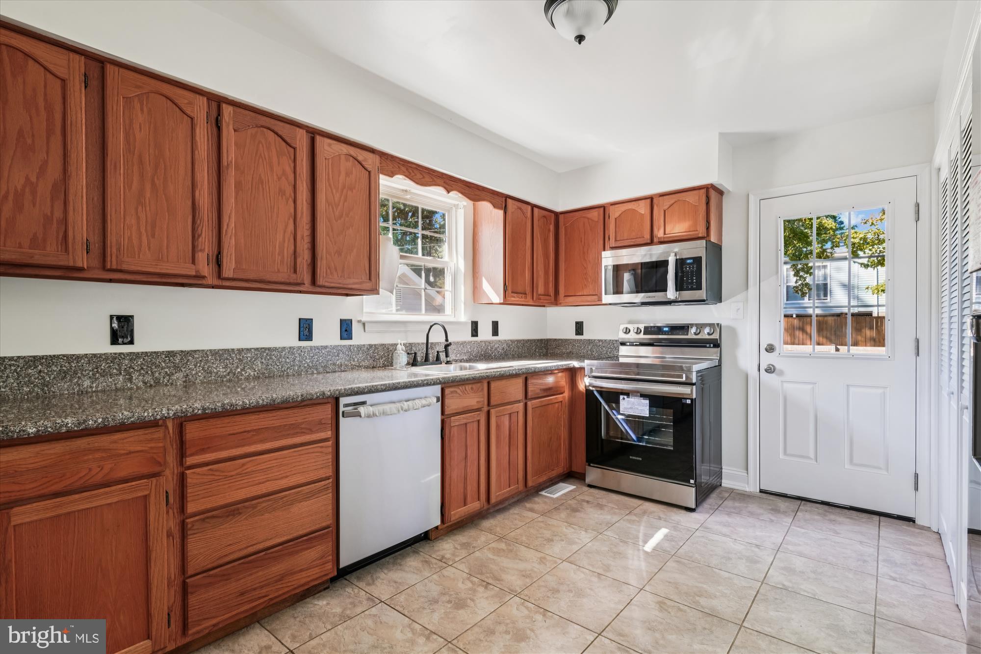 3831 8th Street North Beach, MD 20714 - Photo 7 of 37 a kitchen with stainless steel appliances granite countertop a stove sink and microwave