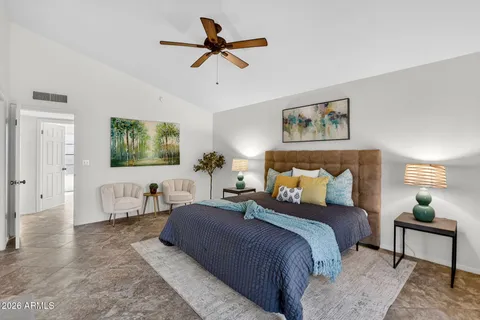 a bedroom with a bed and painting on the wall