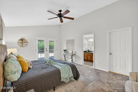 a bedroom with a bed a couch and a potted plant