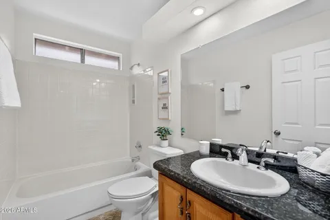 a bathroom with a granite countertop sink a mirror and a mirror