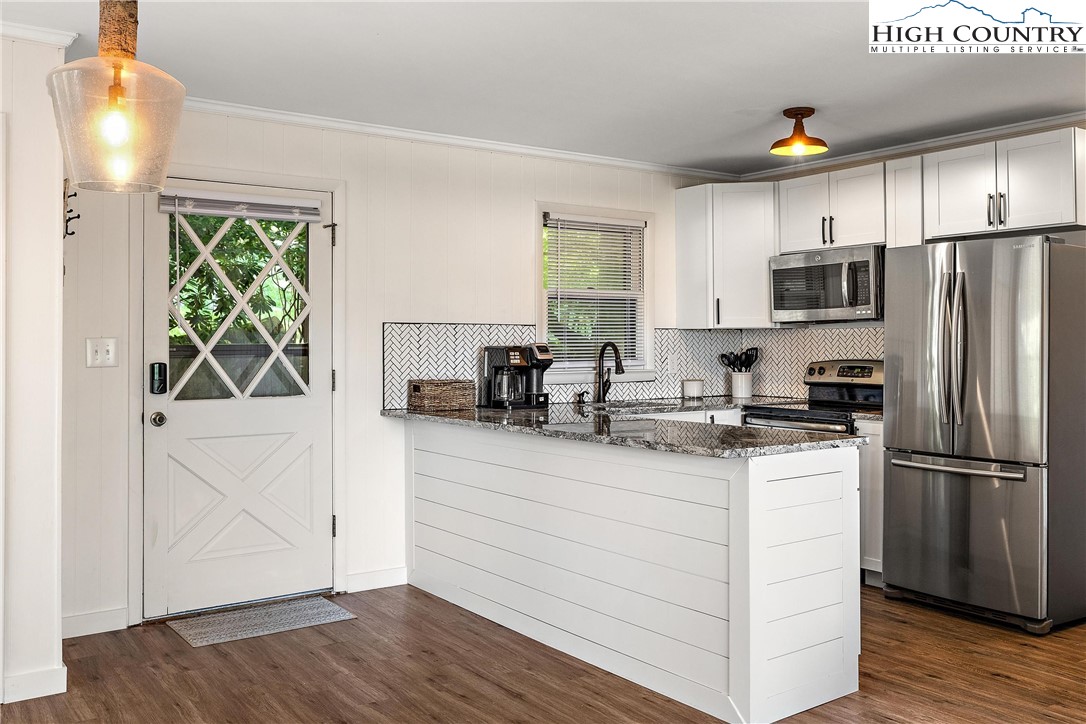 a kitchen with a refrigerator and a stove top oven