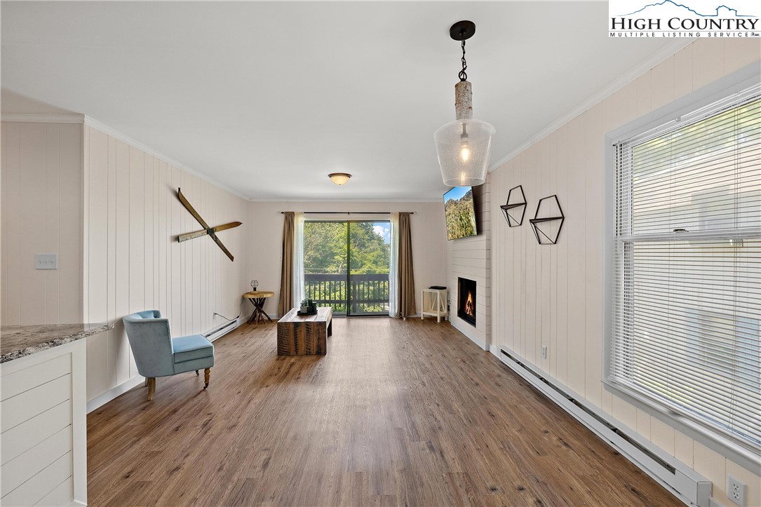 101 Mid Holiday Lane, Unit E217 Beech Mountain, NC 28604 - Photo 11 of 43 a view of a livingroom with furniture wooden floor windows and a chandelier