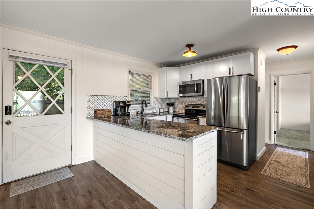101 Mid Holiday Lane, Unit E217 Beech Mountain, NC 28604 - Photo 17 of 43 a kitchen with stainless steel appliances granite countertop a refrigerator sink and stove