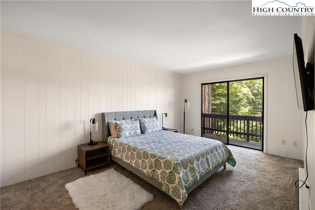 101 Mid Holiday Lane, Unit E217 Beech Mountain, NC 28604 - Photo 18 of 43 a bedroom with a bed a flat screen tv and next to a window