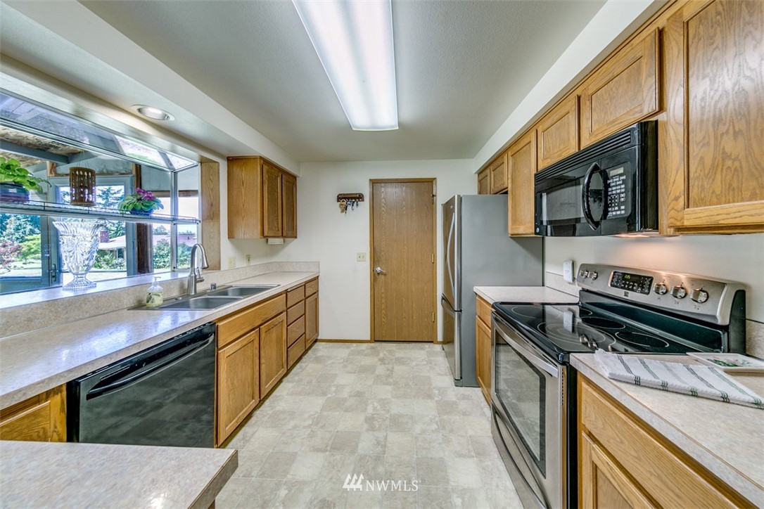 422 Hulse Road Port Angeles, WA 98362 - Photo 14 of 40 a kitchen with stainless steel appliances granite countertop a stove a sink and a microwave
