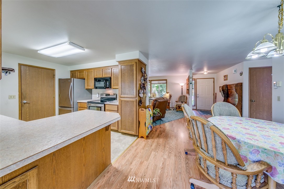 422 Hulse Road Port Angeles, WA 98362 - Photo 20 of 40 a large kitchen with a table chairs refrigerator and a stove top oven