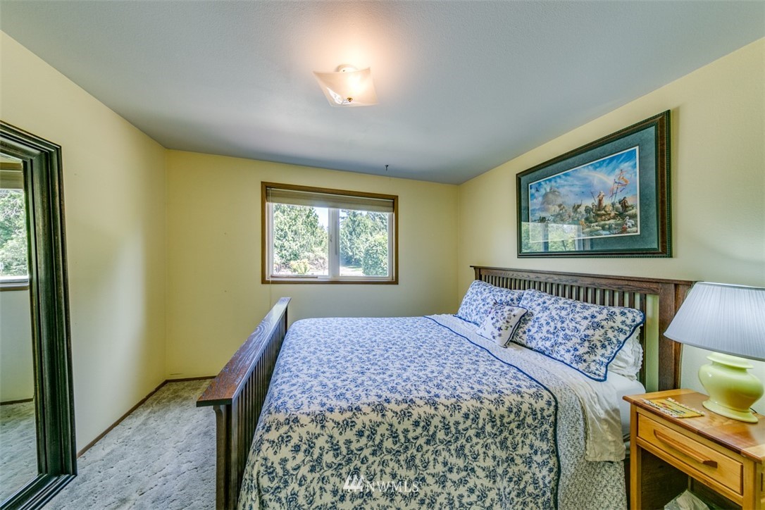 422 Hulse Road Port Angeles, WA 98362 - Photo 23 of 40 a bedroom with a bed and a painting on the wall