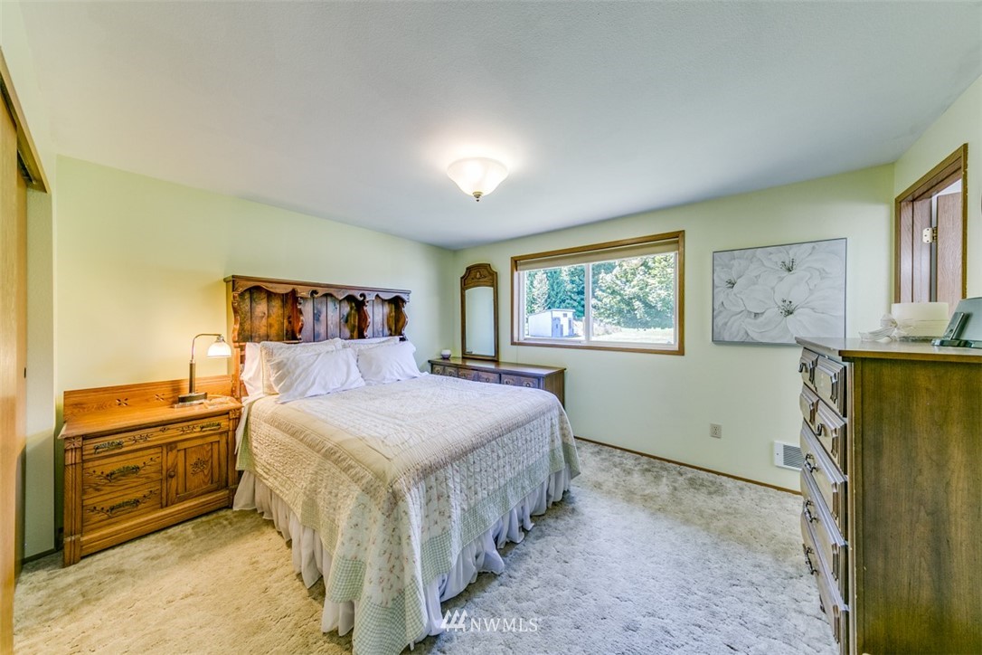 422 Hulse Road Port Angeles, WA 98362 - Photo 27 of 40 a spacious bedroom with a bed and a cabinets