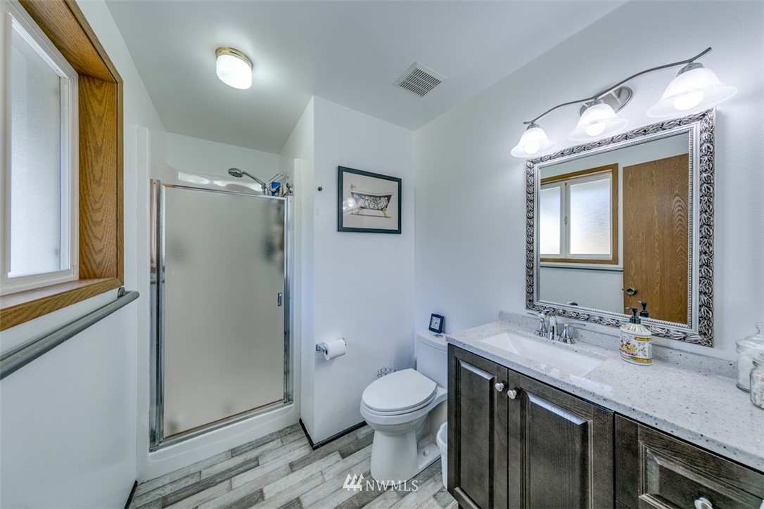 422 Hulse Road Port Angeles, WA 98362 - Photo 29 of 40 a bathroom with a granite countertop toilet a sink and a mirror