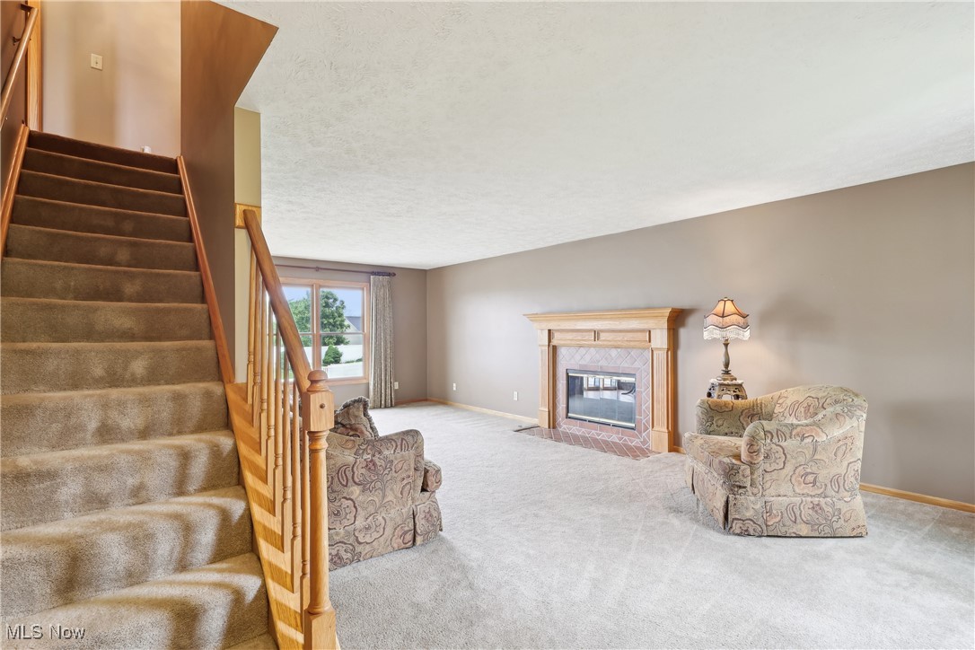 108 Joshua Drive Rittman, OH 44270 - Photo 3 of 44 Living area featuring carpet, stairs, baseboards, and a high end fireplace