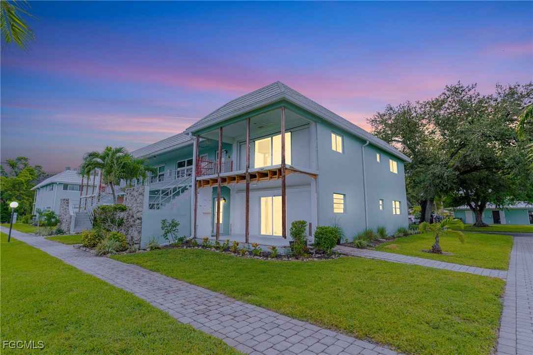 3225 East Riverside Drive, Unit 34C Fort Myers, FL 33916 - Photo 2 of 50 a front view of a house with a yard and trees