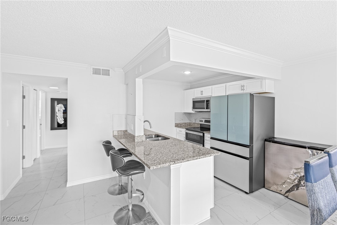 3225 East Riverside Drive, Unit 34C Fort Myers, FL 33916 - Photo 23 of 50 a kitchen with stainless steel appliances granite countertop a refrigerator and a stove top oven