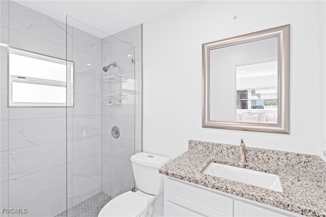 3225 East Riverside Drive, Unit 34C Fort Myers, FL 33916 - Photo 29 of 50 a bathroom with a granite countertop sink toilet a mirror and shower