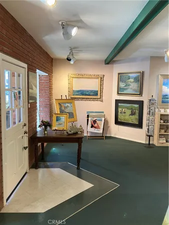 a living room with furniture a flat screen tv and paintings on the wall