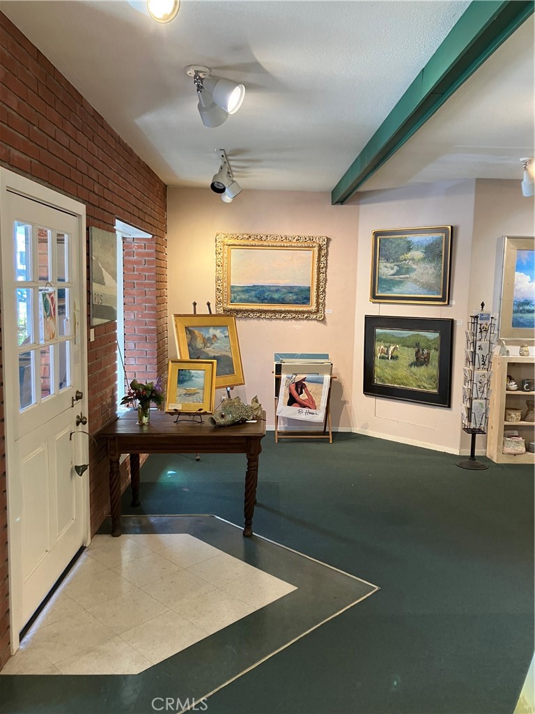 724 Main Street Cambria, CA 93428 - Photo 7 of 24 a living room with furniture a flat screen tv and paintings on the wall