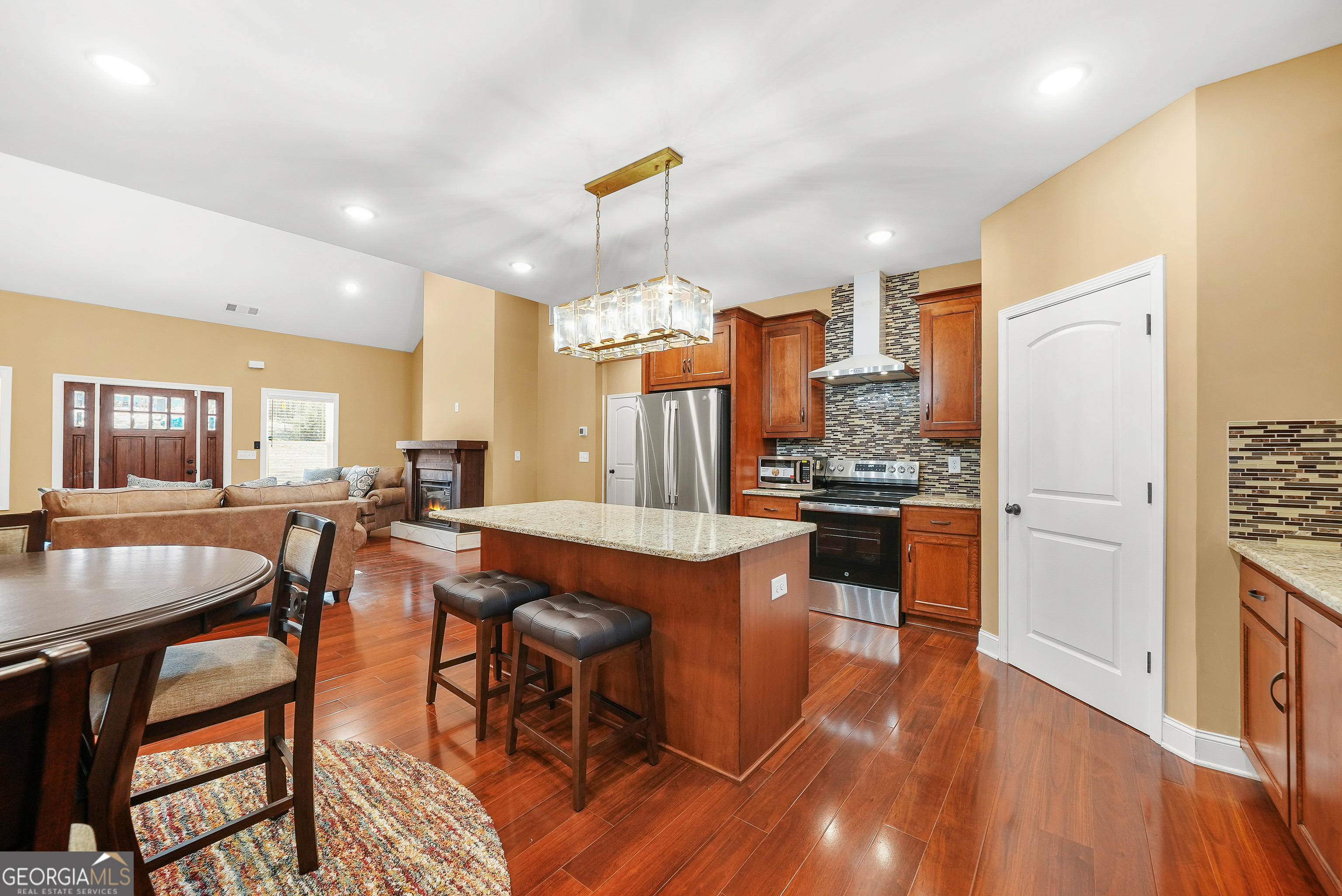 1663 Piedmont Road Griffin, GA 30224 - Photo 13 of 35 a kitchen with stainless steel appliances kitchen island granite countertop a table chairs and a refrigerator