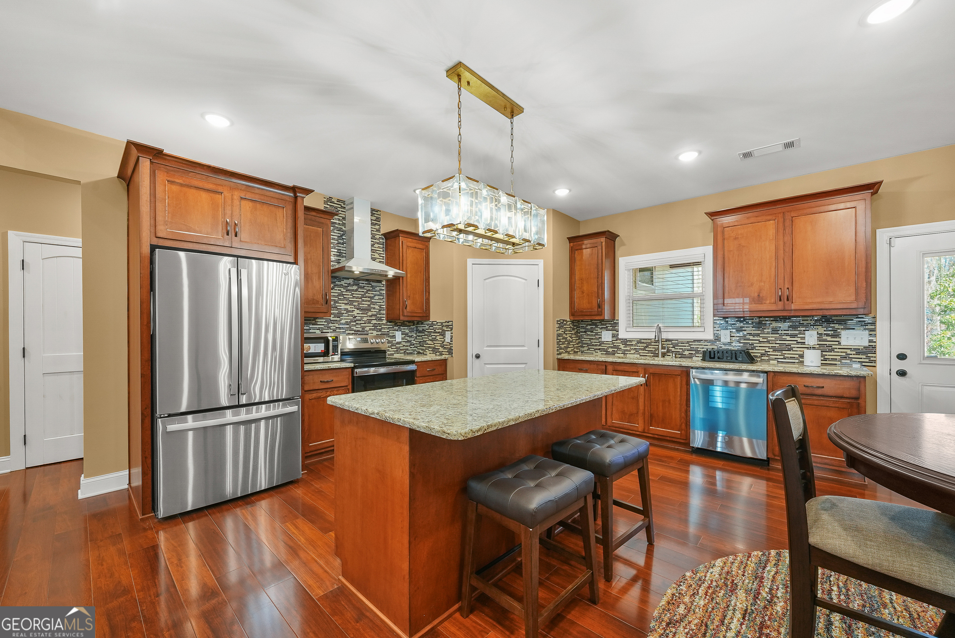1663 Piedmont Road Griffin, GA 30224 - Photo 14 of 35 a kitchen with stainless steel appliances granite countertop a refrigerator a stove top oven a sink dishwasher and wooden cabinets with wooden floor