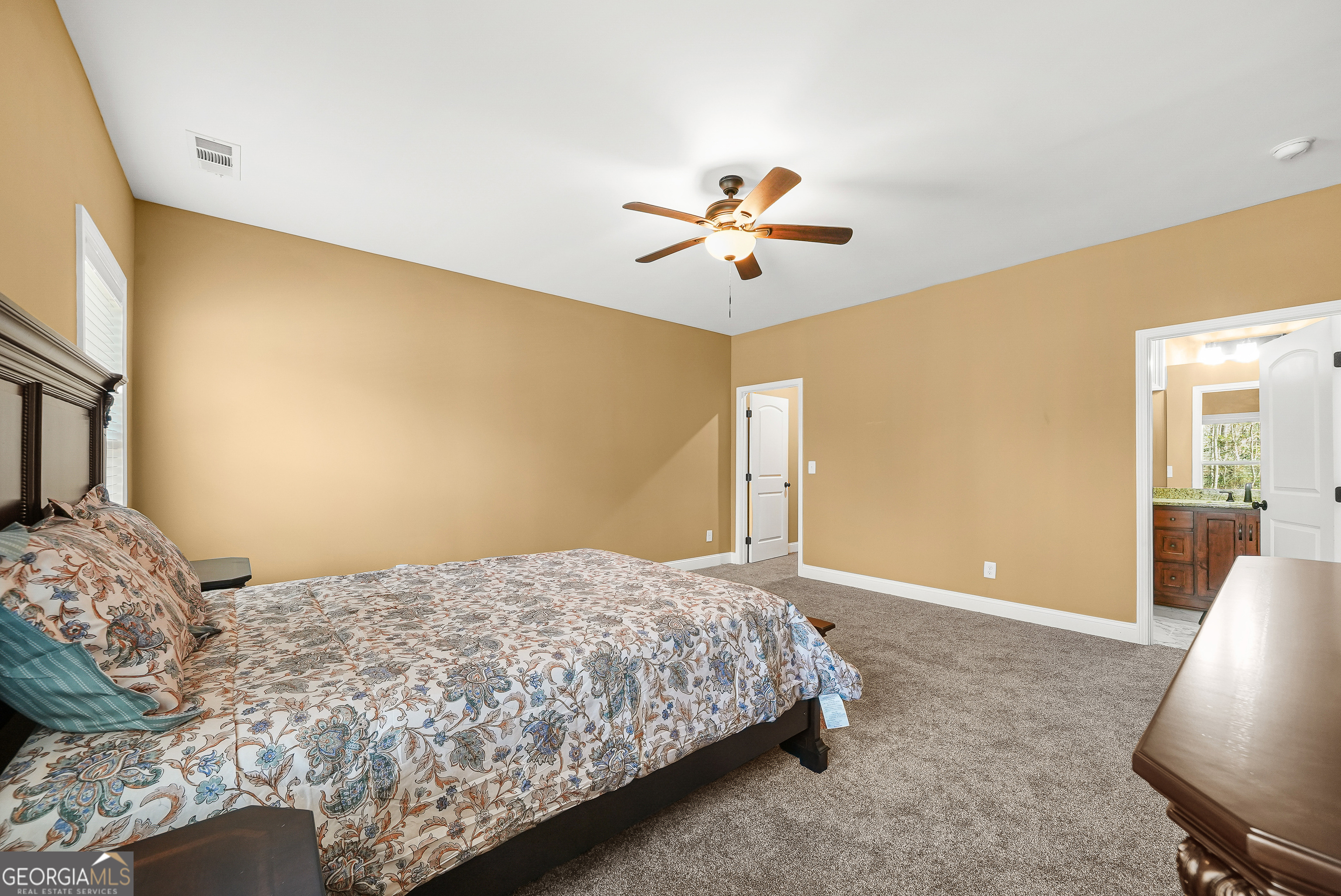 1663 Piedmont Road Griffin, GA 30224 - Photo 17 of 35 a bedroom with a large bed and a chandelier