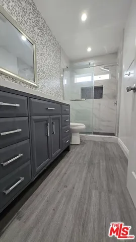 a spacious bathroom with a granite countertop sink a toilet and a mirror