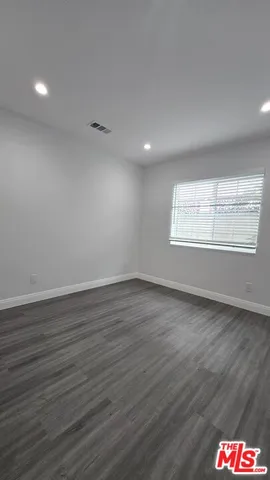 an empty room with wooden floor and closet