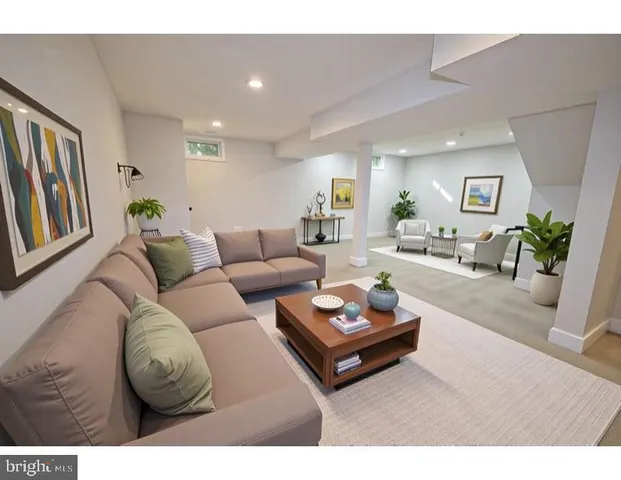 a living room with furniture a rug kitchen view and a window