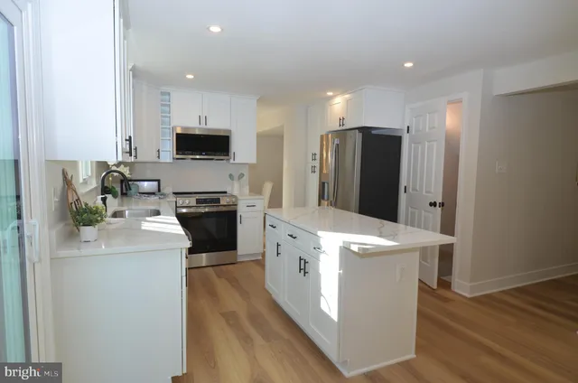 a kitchen with a sink a stove a refrigerator and a microwave