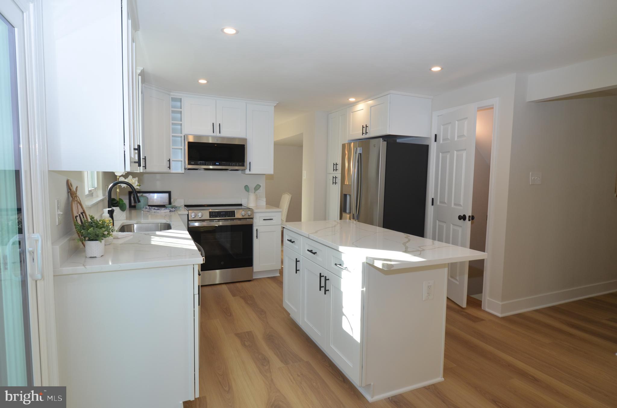 8375 Magic Leaf Road Springfield, VA 22153 - Photo 8 of 43 a kitchen with stainless steel appliances a refrigerator stove and microwave