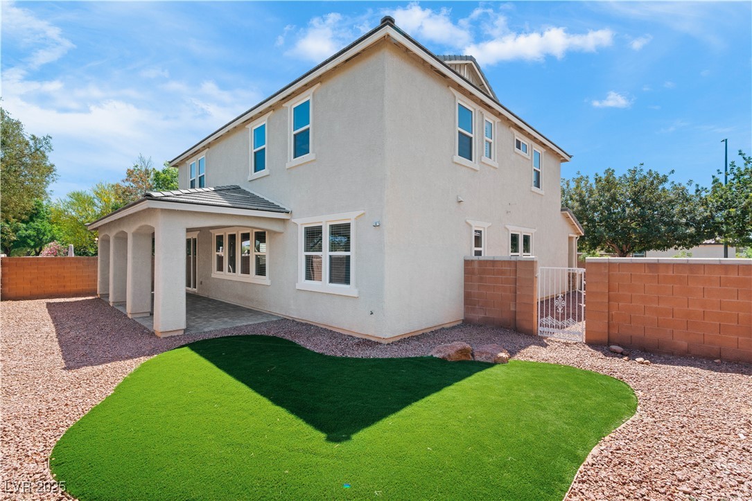 312 Pocono Ranch Avenue North Las Vegas, NV 89031 - Photo 2 of 34 Rear view of house with a patio, a lawn, stucco siding, and a fenced backyard
