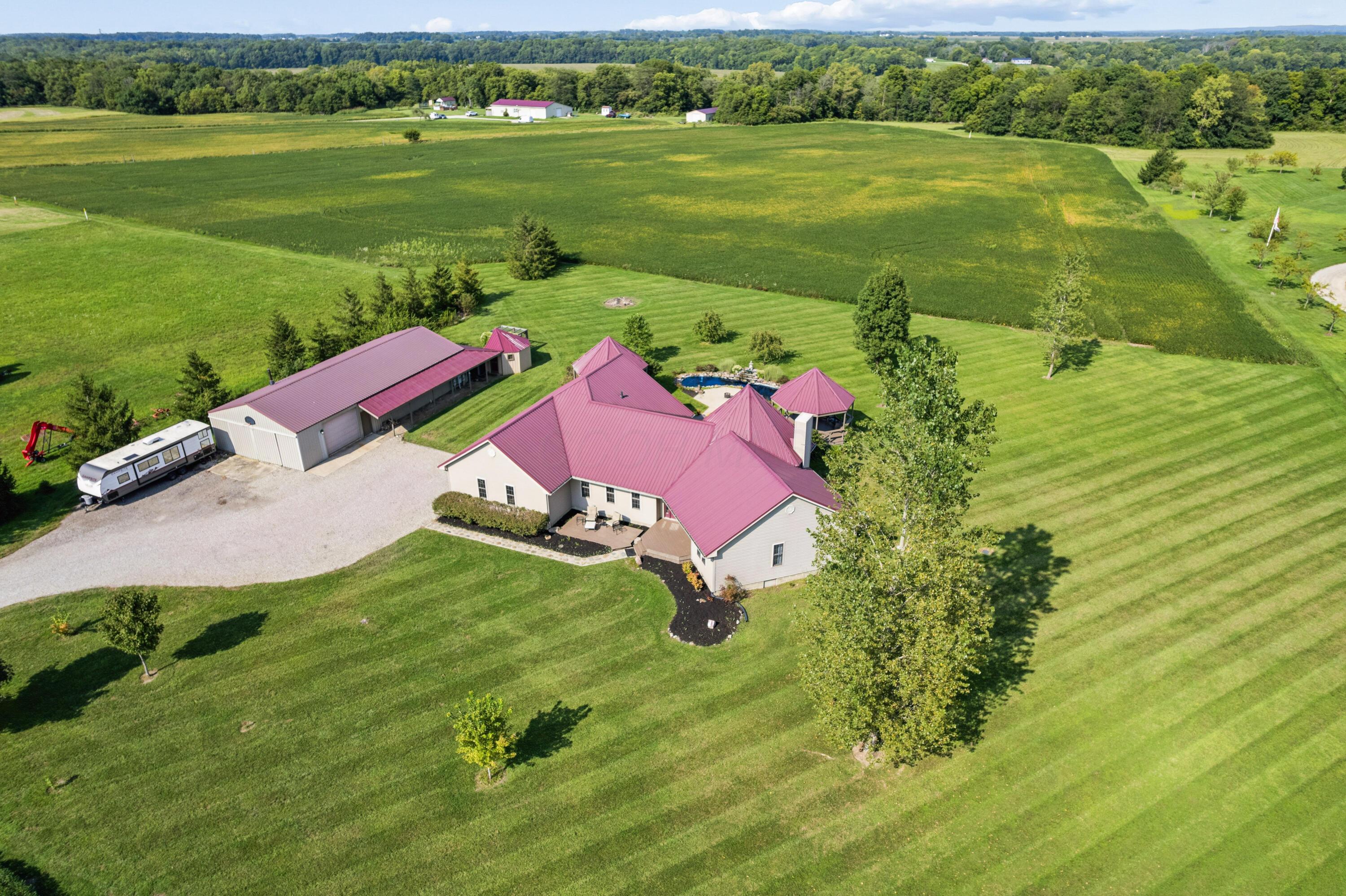 18964 London Road Circleville, OH 43113 - Photo 1 of 57 Expansive property featuring a residence with a metal roof, a detached pole barn with a metal roof, a gravel driveway, and established landscaping