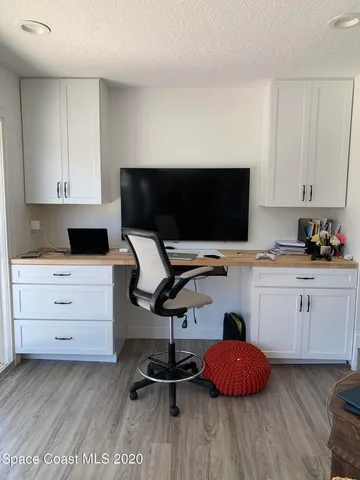 a kitchen with a sink cabinets and a flat screen tv