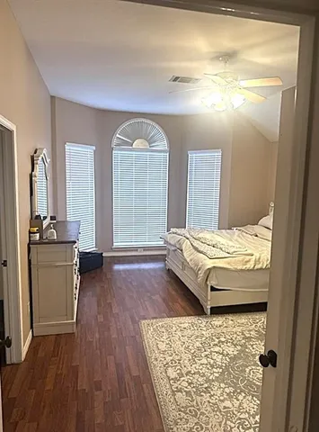 a bedroom with a bed and wooden floor