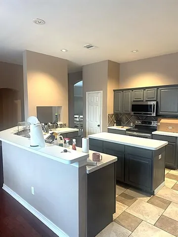 a kitchen with a sink stove and cabinets